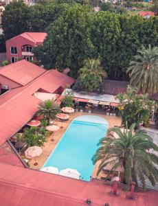 an overhead view of a swimming pool with chairs and umbrellas at Relais des Plateaux & Spa&ndash; Ivato International Airport in Antananarivo