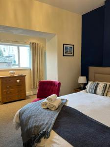 ein Schlafzimmer mit einem Bett und einem roten Stuhl in der Unterkunft Beautifully presented Victorian Apartment within walking distance to Llandudno beach in Llandudno + 22 Fotos