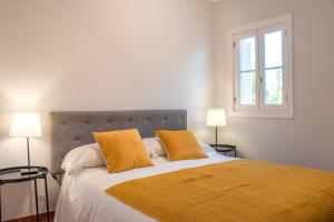 1 dormitorio con 1 cama grande y 2 almohadas amarillas en Una casita en el campo dentro de la ciudad en Avila