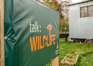 a green sign with a tree on it in a yard at Old Buckenham Country Park in Old Buckenham