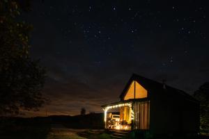 a small house lit up at night with lights at Gnievo in Międzylesie