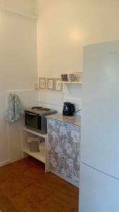 a kitchen with a counter top with a microwave at Poppies Beach Bach in Matavera