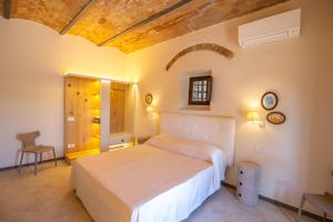 1 dormitorio con 1 cama blanca en una habitación en Tenuta di Montemassi Podere Raspollino, en Montemassi