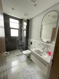 Premium hotel apartment Aeon towers Sheikh Zayed City في السادس من أكتوبر: حمام مع حوض ومرحاض ومرآة