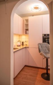 een boog leidt naar een keuken met witte kasten bij Romantik Bdsm Apartment Skyview in Remscheid