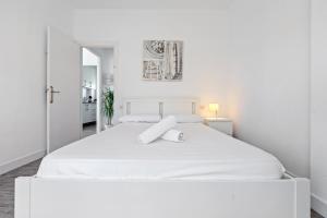 a white bedroom with a large white bed at Sweet apt- Sea Views in El Vendrell