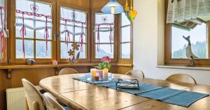 a dining room with a wooden table and windows at Severinenhof in Schramberg