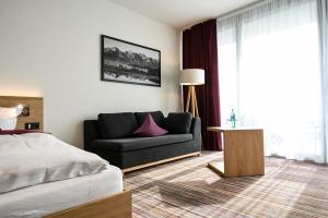 a living room with a couch and a bed at Soloplan City Resort in Kempten