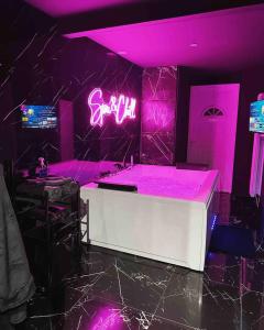 a purple room with a sink and neon signs at Appartement d'une chambre avec sauna et wifi a Villeurbanne in Villeurbanne