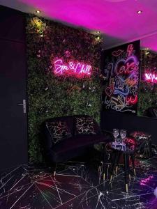 a room with a couch and a wall with neon signs at Appartement d'une chambre avec sauna et wifi a Villeurbanne in Villeurbanne