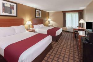 a hotel room with two beds and a flat screen tv at Baymont by Wyndham New Buffalo in New Buffalo