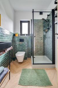 uma casa de banho com uma cabina de duche em vidro e um WC. em Gnievo 11 em Międzylesie