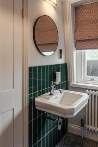 une salle de bain avec un lavabo et un miroir dans l'établissement St. David's Hotels Paddington, à Londres