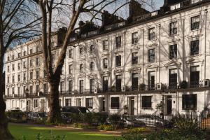 a large white building with a tree in front of it at St. David's Hotels Paddington in London