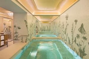 a swimming pool in a hotel with a painting on the wall at La Fantaisie in Paris