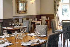 uma sala de jantar com mesas e cadeiras com copos de vinho em Best Western Valley Hotel em Ironbridge