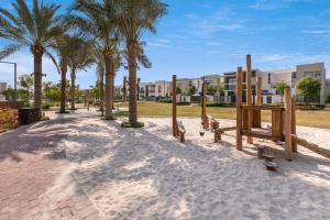 a park with palm trees and a playground at Keysplease Beautiful 3 B/R villa 16, Arabian Ranches in Dubai