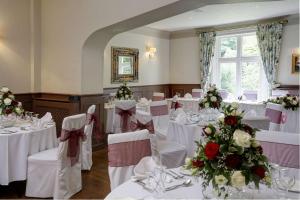 a room with white tables and chairs with flowers at Best Western Valley Hotel in Ironbridge