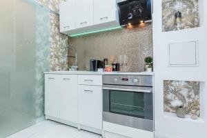 eine Küche mit weißen Schränken und einem Backofen in der Unterkunft Zichy Luxury Apartment in Budapest