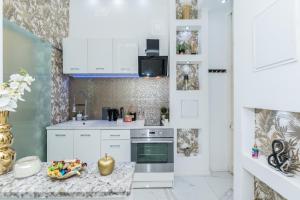 eine Küche mit weißen Schränken und einer Marmoroberfläche in der Unterkunft Zichy Luxury Apartment in Budapest