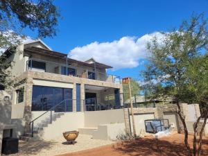 uma imagem de uma casa com céu azul em Rosendal Kruger View Villa em Marloth Park