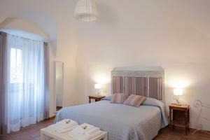 ein Schlafzimmer mit einem Bett mit zwei Tischen und zwei Lampen in der Unterkunft Casa Vèra Camelia Apartment in Orvieto