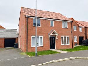 a red brick house with a black door at Spacious 4 Bed Peterborough House With Parking in Peterborough