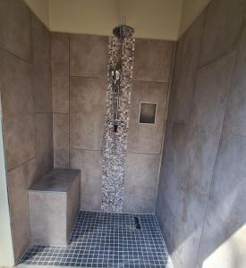 um chuveiro na casa de banho com piso em azulejo em Rosendal Kruger View Villa em Marloth Park
