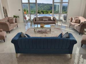 a living room with a blue couch and a table at Villa Luiz Danneel: Vipingo Ridge in Mombasa