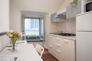 una cocina con una mesa con un jarrón de flores. en Casa Vèra Camelia Apartment, en Orvieto