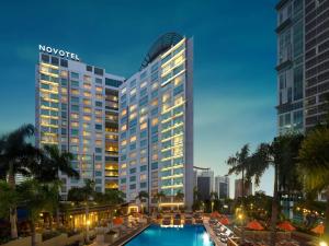 a hotel with a pool in front of a building at Novotel Manila Araneta City Hotel in Manila