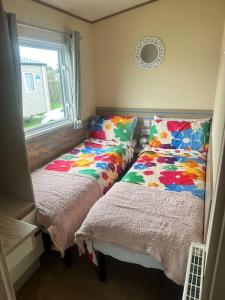 a bedroom with two beds and a window at Serenity Coast in Wyke Regis