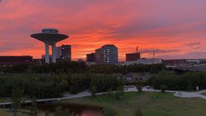 a city skyline with a tower in the sunset at Hyllie Vattentorn in Malmö