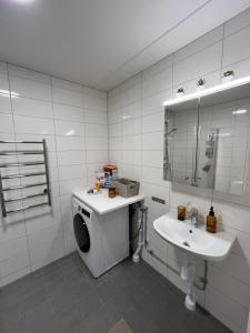 a bathroom with a washing machine and a sink at Hyllie Vattentorn in Malmö