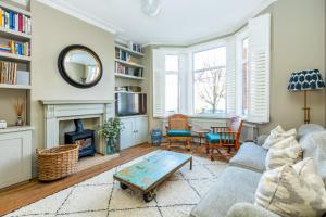 a living room with a couch and a table at Fantastic Edwardian 3BR House w/Gdn, Kensal Green in London
