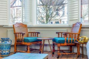 a porch with two chairs and a table at Fantastic Edwardian 3BR House w/Gdn, Kensal Green in London