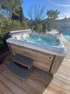 bañera de hidromasaje en una terraza de madera en DOMAINE DE LA SOURCO - Villa, Maisons & Chalet, Magnifique Havre De Paix En Provence en Trans-en-Provence