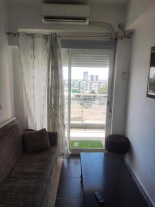 ein Wohnzimmer mit einem Sofa und einem großen Fenster in der Unterkunft Baba Residence in Oran