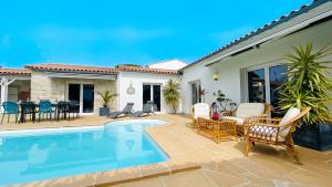 ein Haus mit einem Pool und einer Terrasse in der Unterkunft Magnifique Villa avec sa piscine et son billard in Saint-Martin-de-Ré