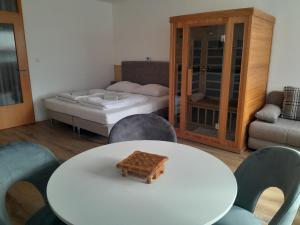 Cette chambre comprend une table, un lit et des chaises. dans l'établissement Apartment Honey Bee with SAUNA, à Kobarid