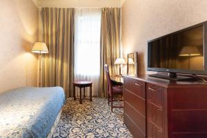 イマトラにあるScandic Imatran Valtionhotelliのベッド1台、薄型テレビが備わるホテルルームです。