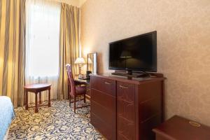 a hotel room with a television on a dresser at Scandic Imatran Valtionhotelli in Imatra