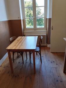 - une table et des chaises en bois dans une chambre avec fenêtre dans l'établissement MAISON ALBA LA SOURCE, à Mazamet