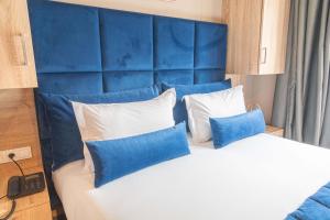 ein Schlafzimmer mit einem blauen Kopfteil und einem Bett mit Kissen in der Unterkunft Rent-inn Boutique Hotel in Rabat