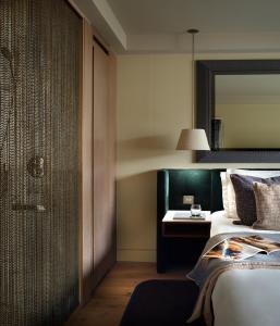 a bedroom with a bed and a table and a mirror at The Hari London in London