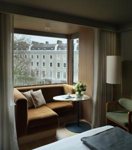 a hotel room with a couch and a window at The Hari London in London