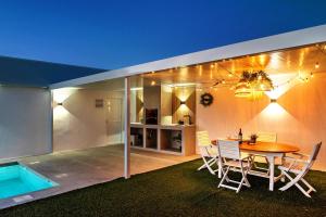 a house with a table and chairs and a swimming pool at Casa Adriana in Conil de la Frontera