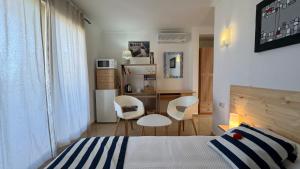 une chambre avec un lit et deux chaises et un bureau dans l'établissement Habitation suite Pego, vue mer 15 mn de Denia 10 mn de la plage, à Pego