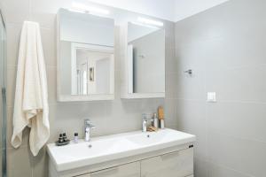 a white bathroom with a sink and a mirror at The granny’s house in Kiáton