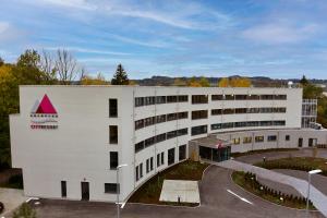 a white building with a red triangle on it at Soloplan City Resort in Kempten
